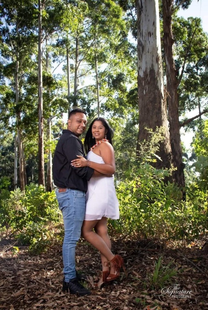 Renesh and Chanelle standing together in the woods